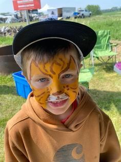 A young boy with his face painted like a tiger.