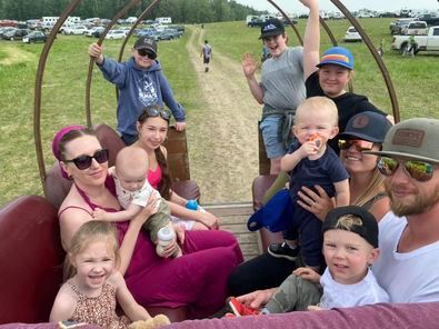 A group of people are riding on the back of a horse drawn carriage.