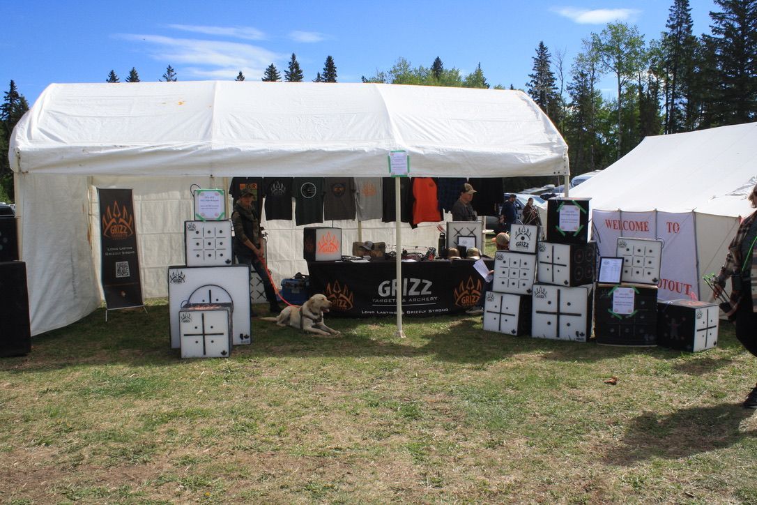 A large white tent is sitting in the middle of a grassy field