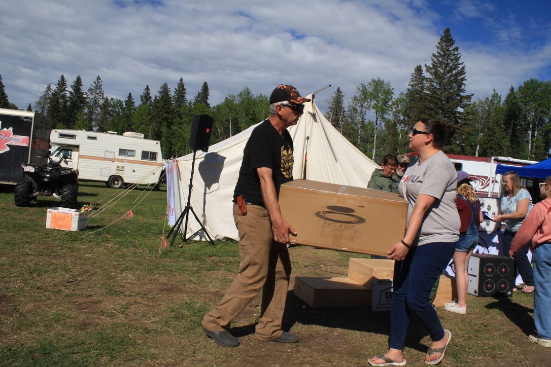 A man and a woman are carrying a large cardboard box