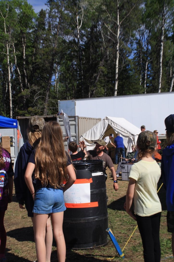 A group of people are standing around a large black barrel.