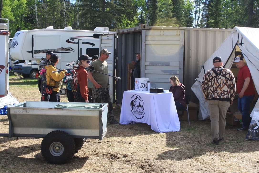 A group of people are standing around a table in front of a trailer.