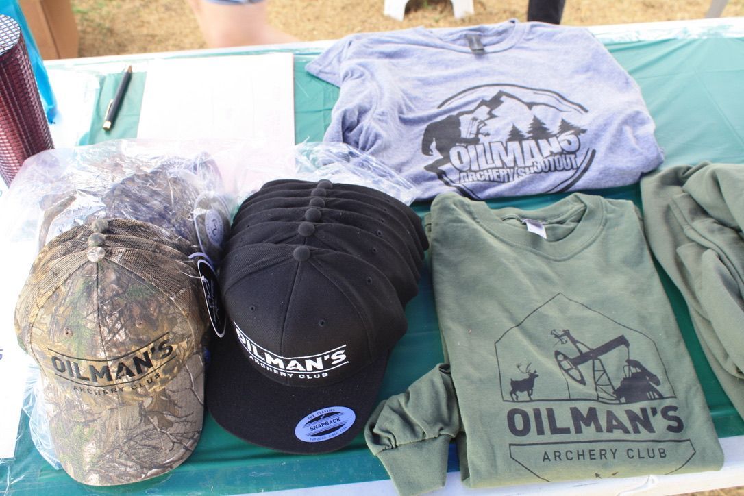 A table with shirts and hats that say oilman 's