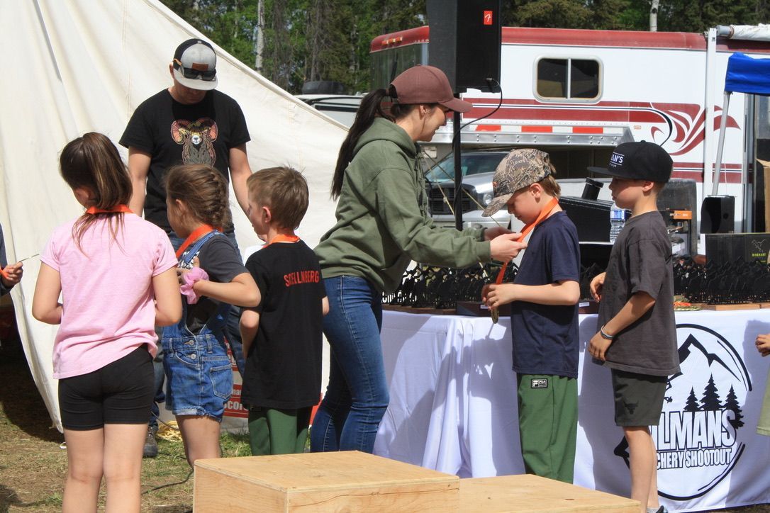 A group of children are standing around a table with a sign that says imax on it