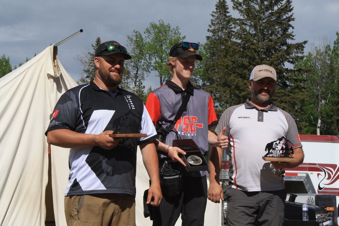 Three men are standing next to each other in front of a tent.