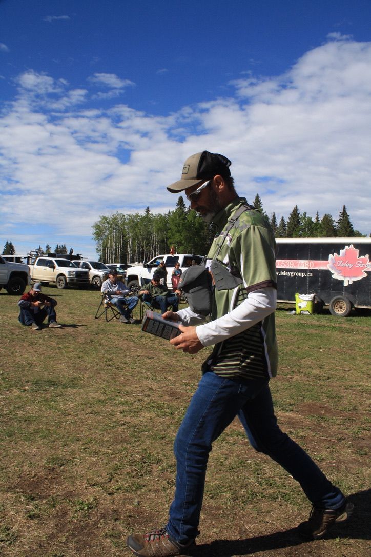 A man is walking in a field holding a tablet.