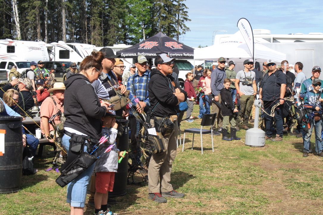 A group of people are standing in a grassy field.