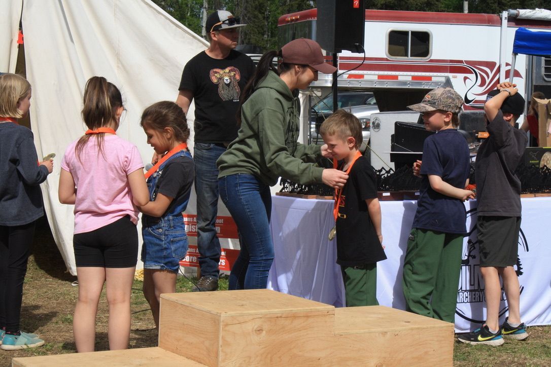 A group of children are standing around a wooden podium.
