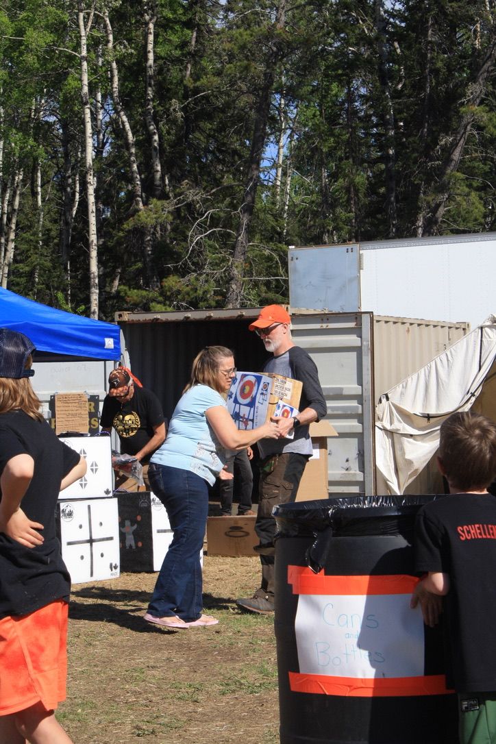 A group of people are standing in a field with a barrel in the foreground