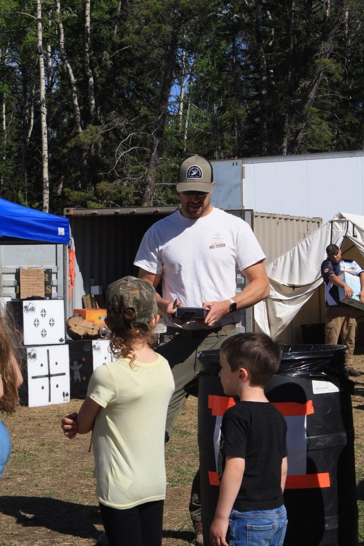 A man in a white shirt is talking to two children