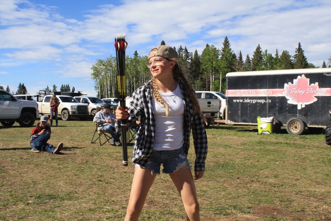 A woman is standing in a field holding a bat.