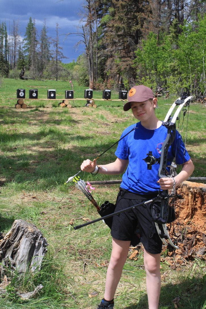 A young archer standing with his bow.
