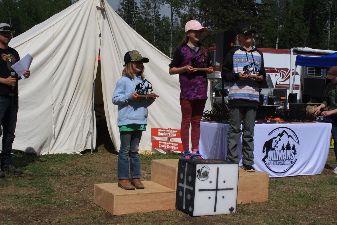 A group of people standing on a podium with a tent in the background