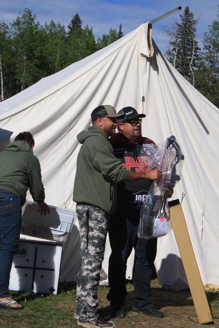 A group of men standing in front of a white tent