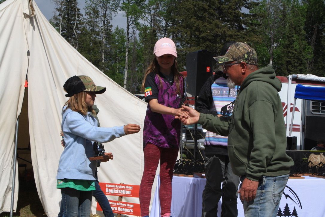 A group of people are shaking hands in front of a tent.