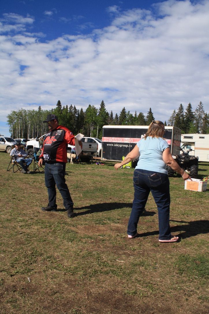 A man and a woman are playing frisbee in a field.