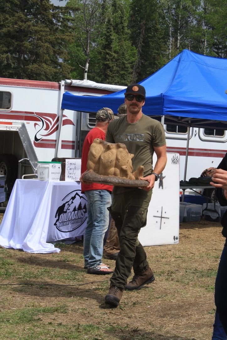 A man is carrying a bag of potatoes in a field.