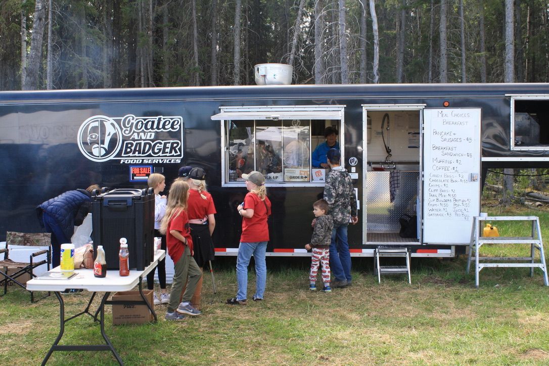 A group of people are standing in front of a food truck.