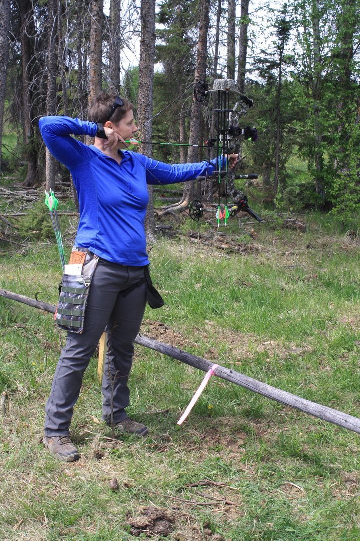 Archery shooting at target in the woods.