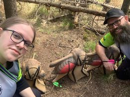 A man and a woman are taking a selfie in the woods.