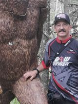 A man is standing next to a statue of a bear.
