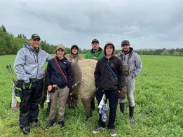 A group of people are posing for a picture in a field.