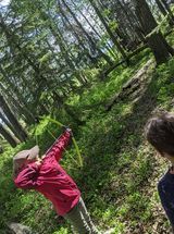 A boy and a girl are playing in the woods.