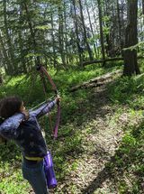 Archery shooting an arrow at a field target.