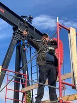 A man is standing on a scaffolding next to a crane.