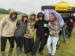 A group of people are posing for a picture in the rain.