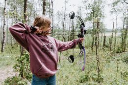 Young woman shooting arrow at target