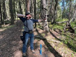 Man shooting bow at target