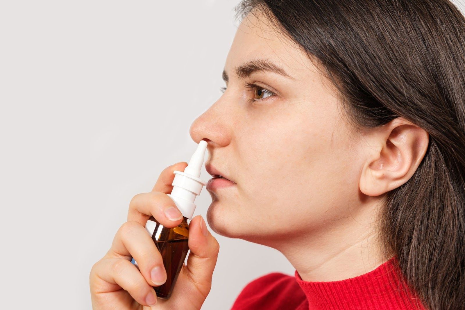 A girl using drop for the nasal spravato image
