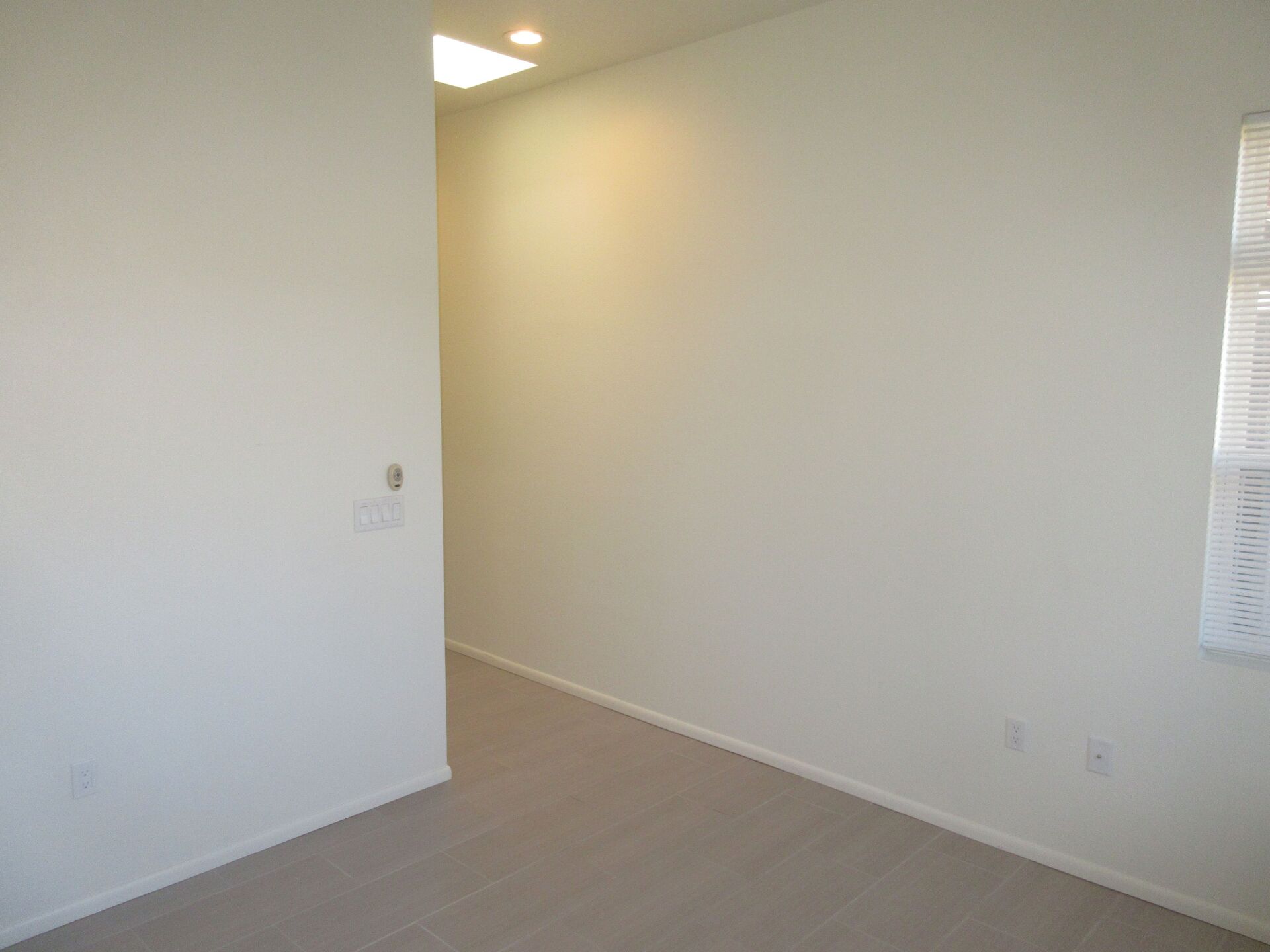 An empty room with white walls and a window.