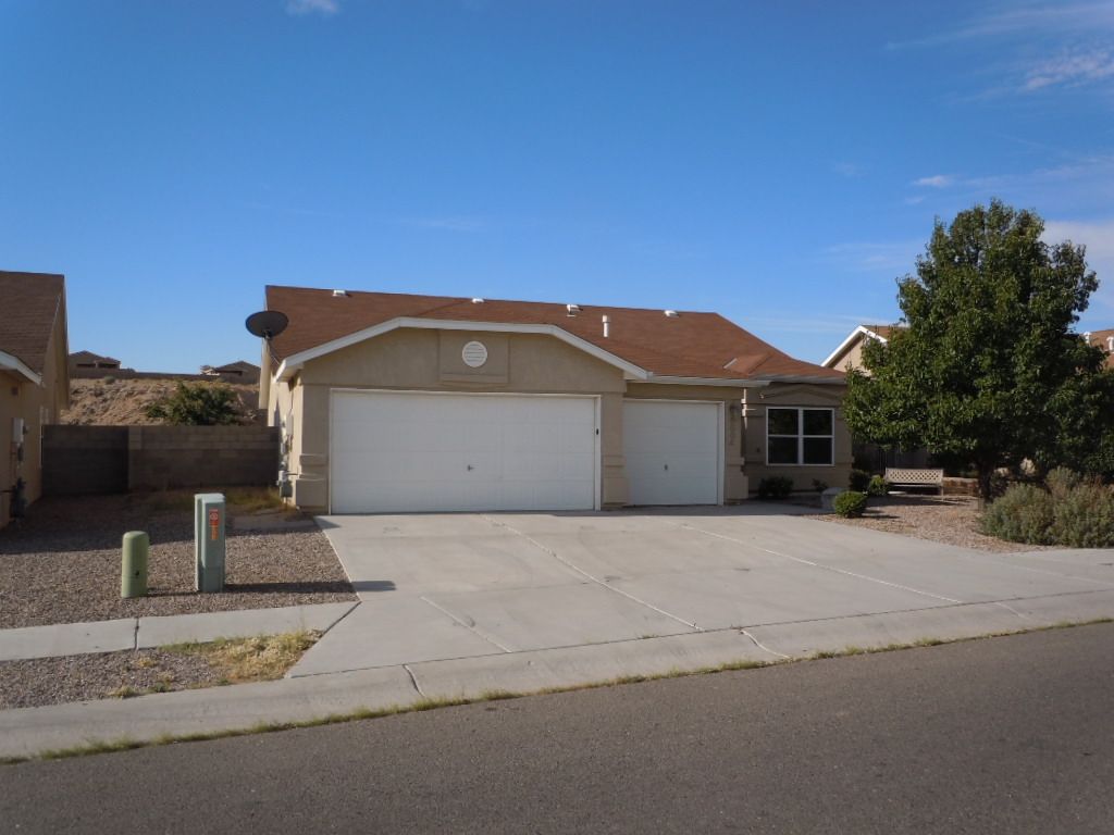 A house with two garage doors and a satellite dish on the roof