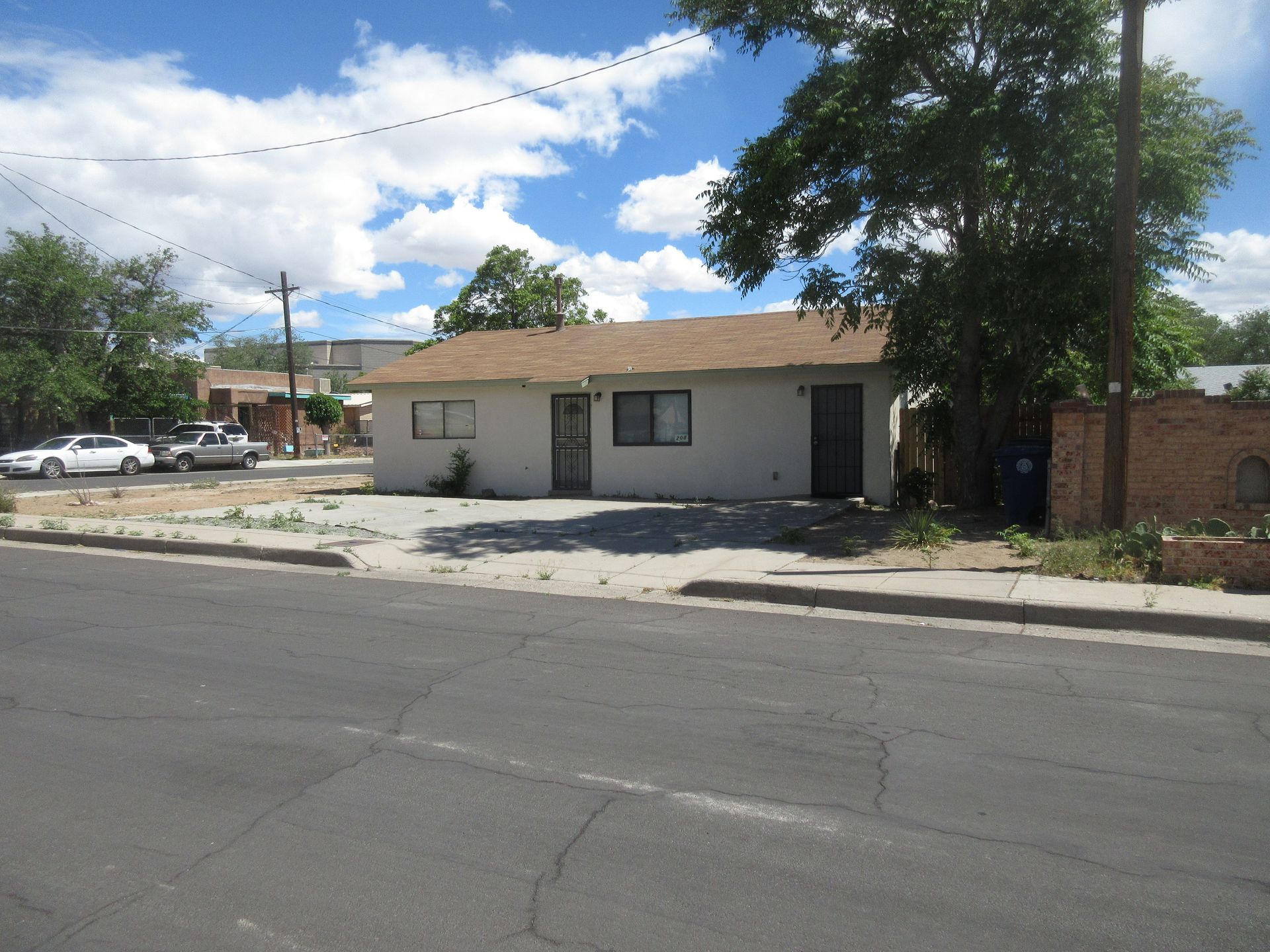 A small white house sits on the corner of a street