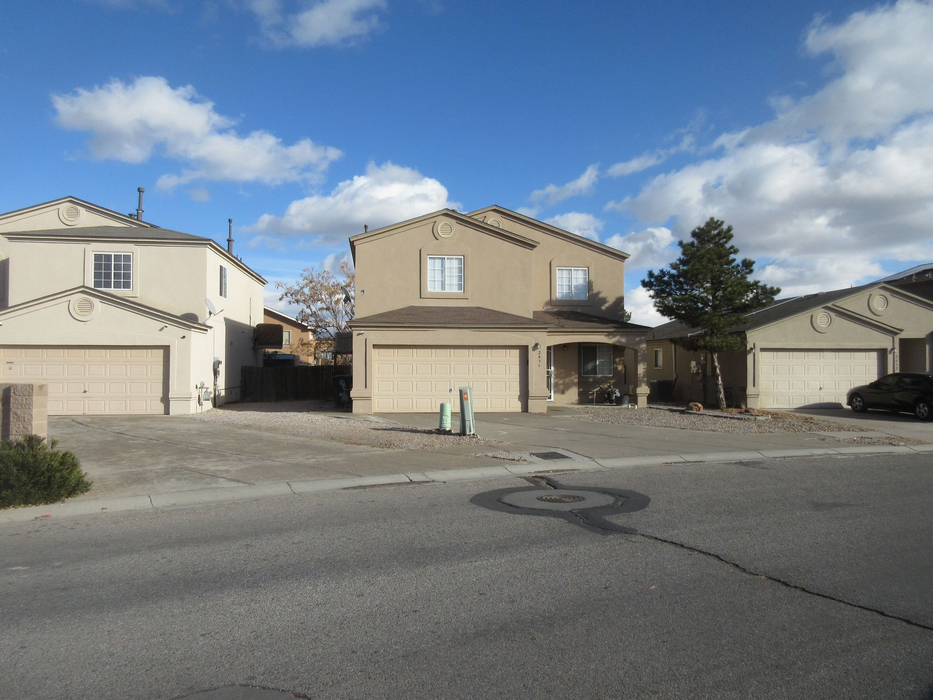 A row of houses with garages are lined up on a street