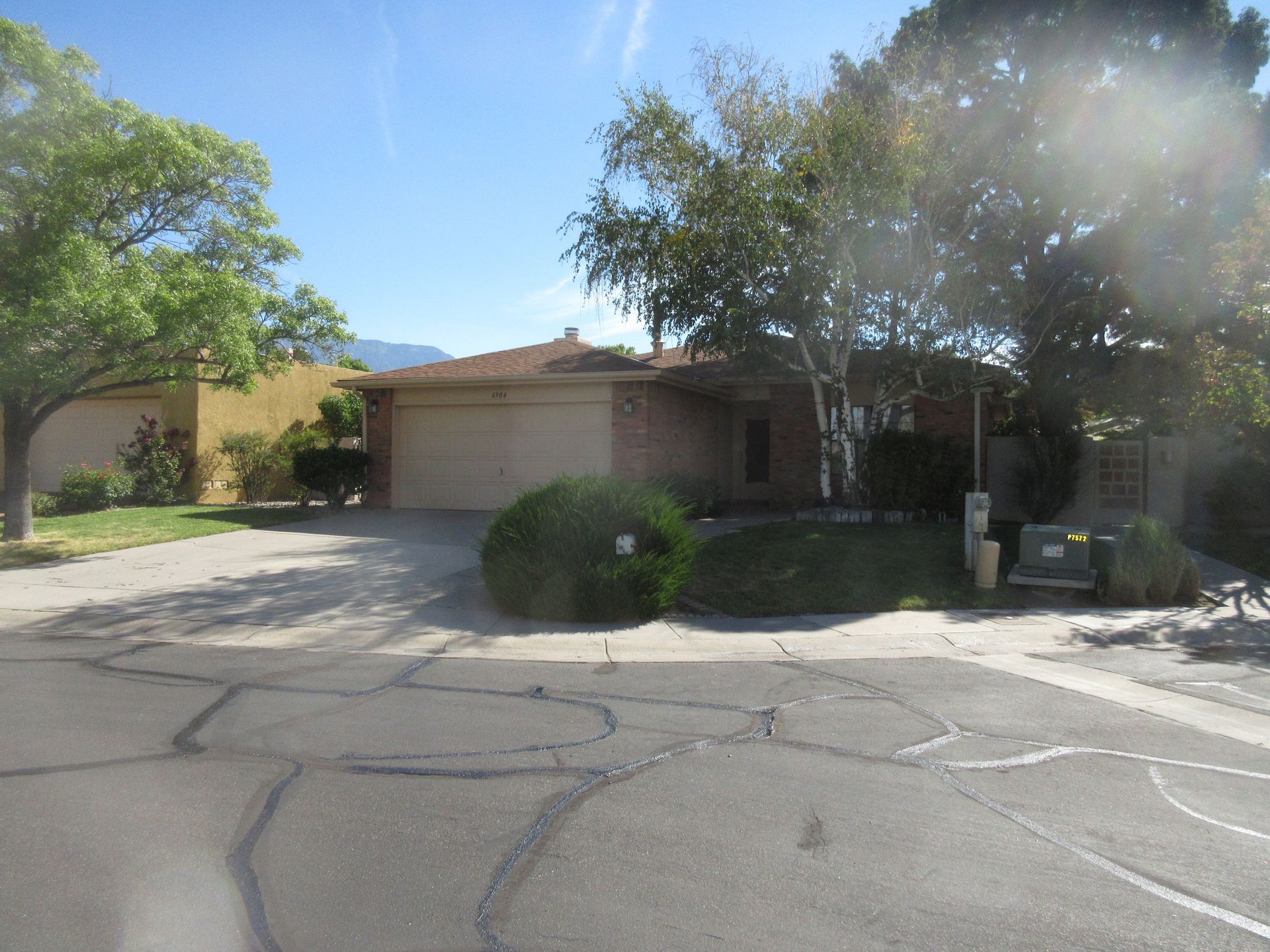A house with a driveway and trees in front of it