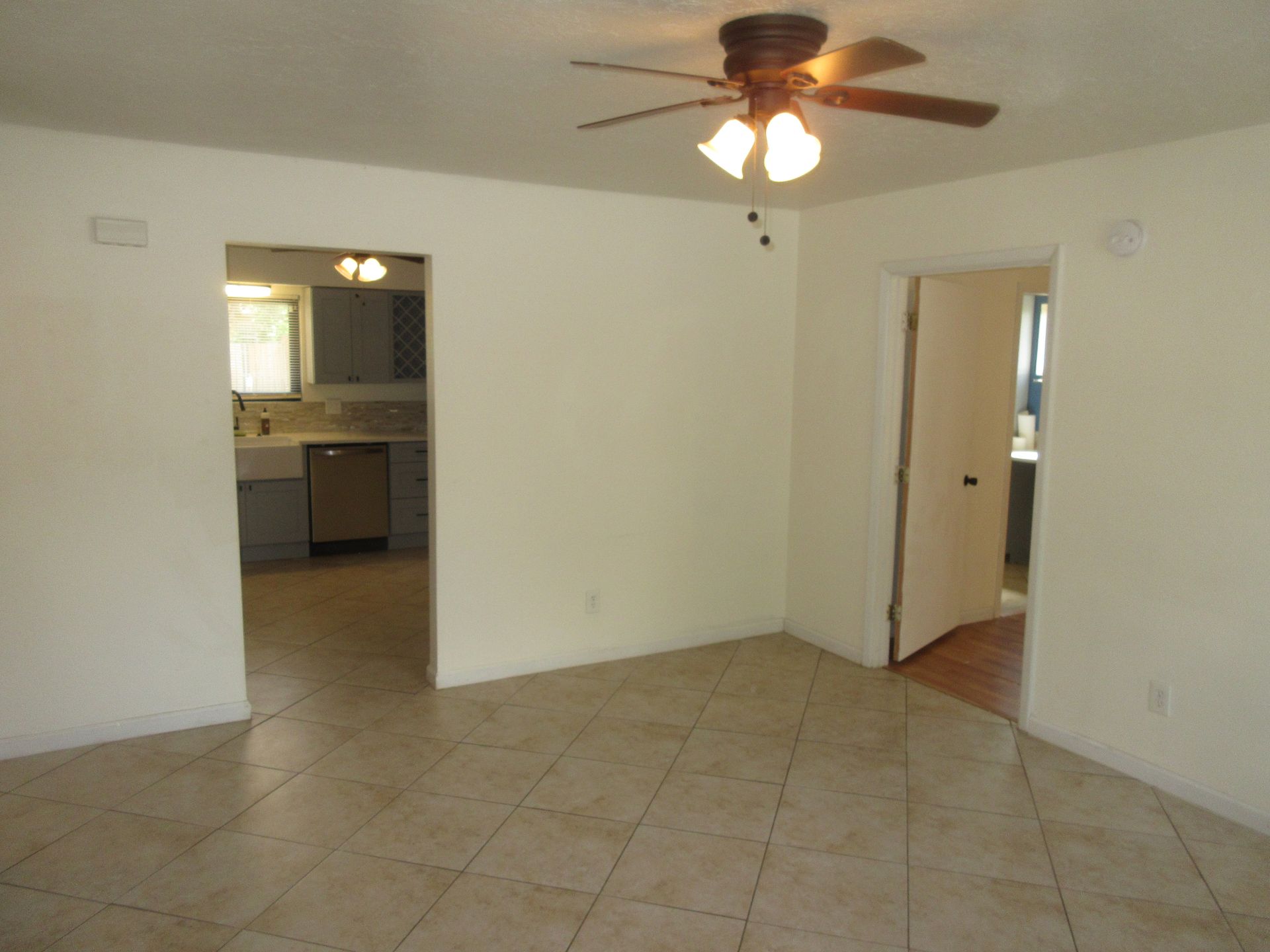 An empty room with a ceiling fan and lights