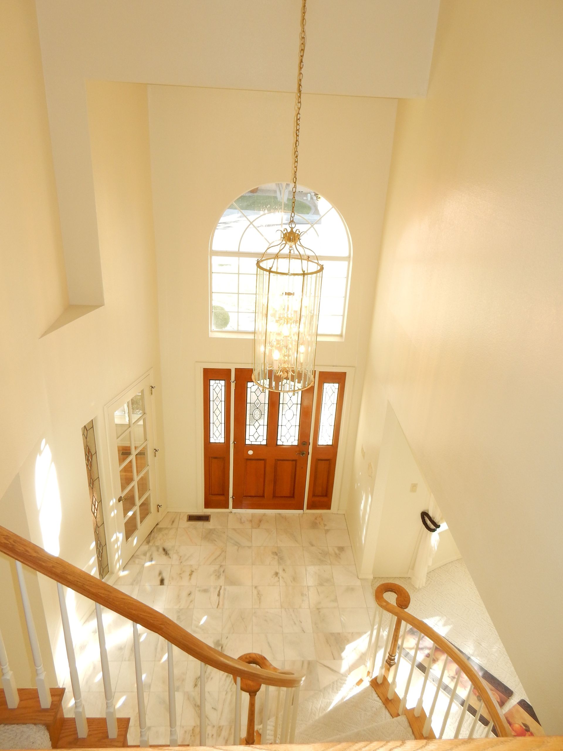 An aerial view of a staircase with a chandelier hanging from the ceiling