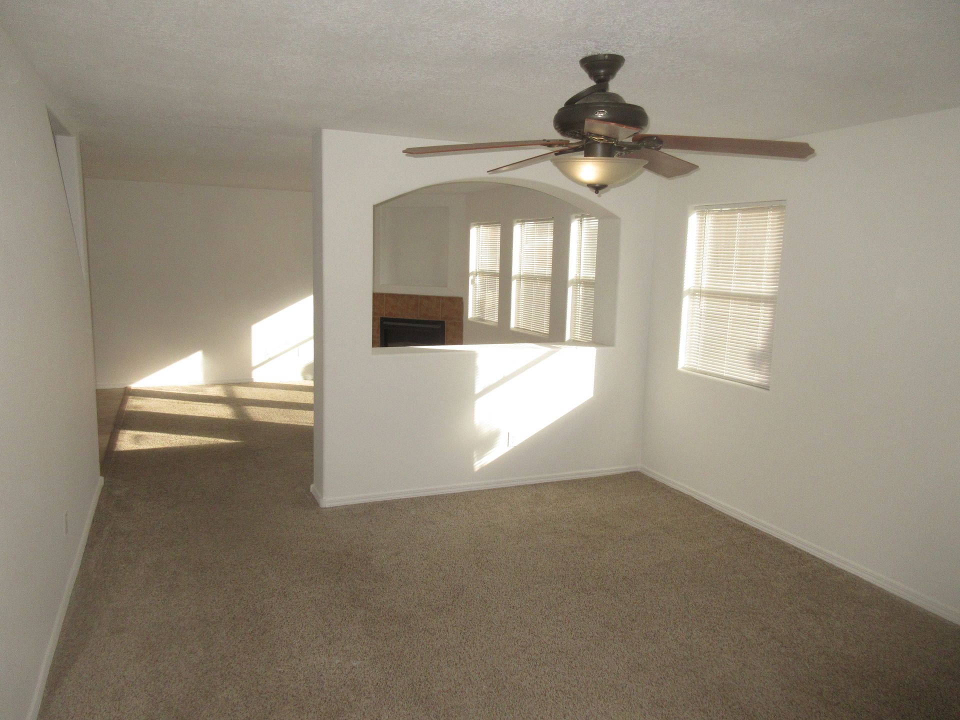 A living room with a ceiling fan and a fireplace