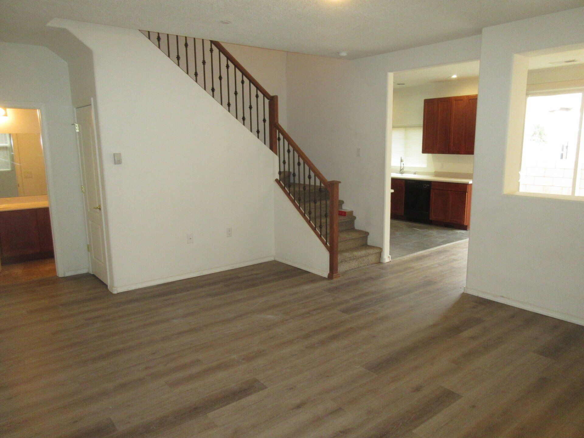 An empty living room with stairs leading up to the second floor