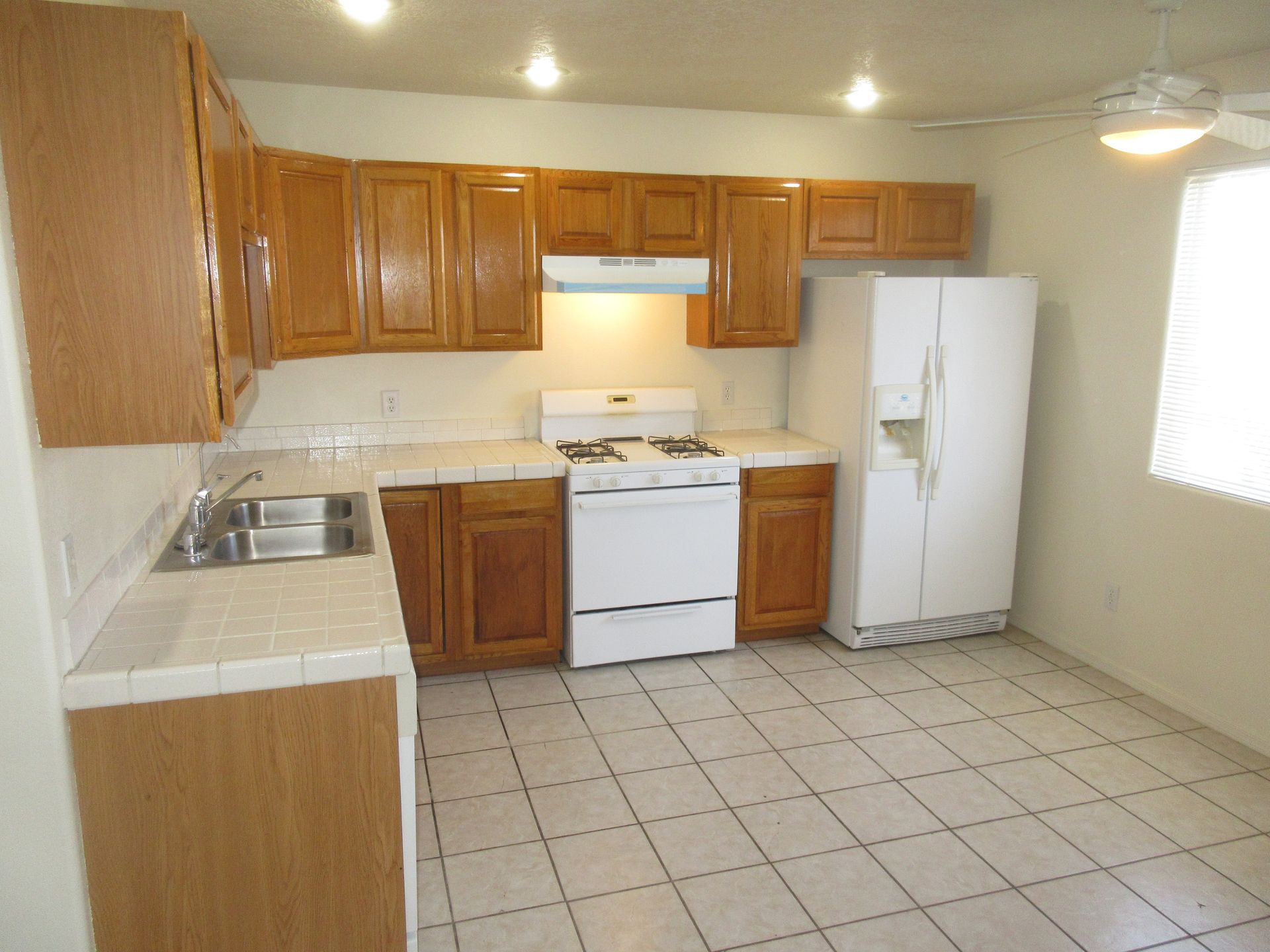 A kitchen with wooden cabinets and a white refrigerator