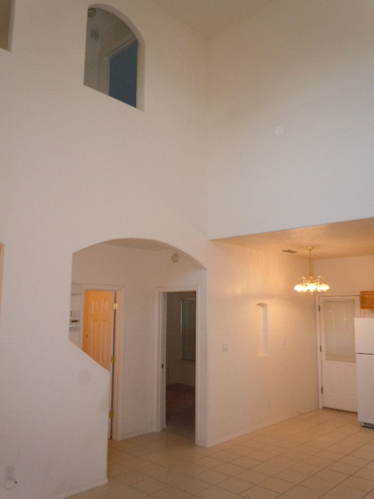 An empty room with white walls and a white refrigerator