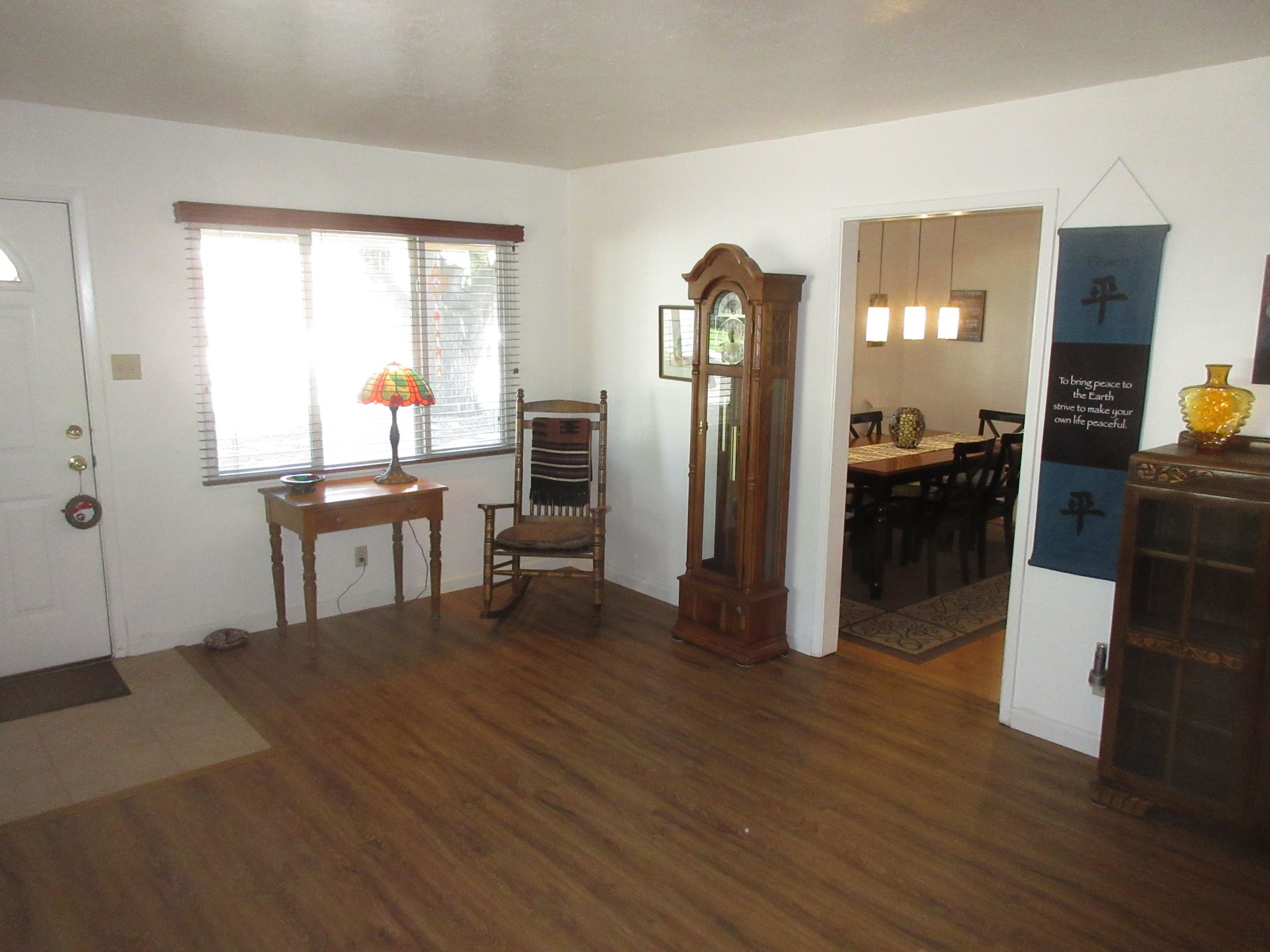 A living room with a rocking chair and a clock