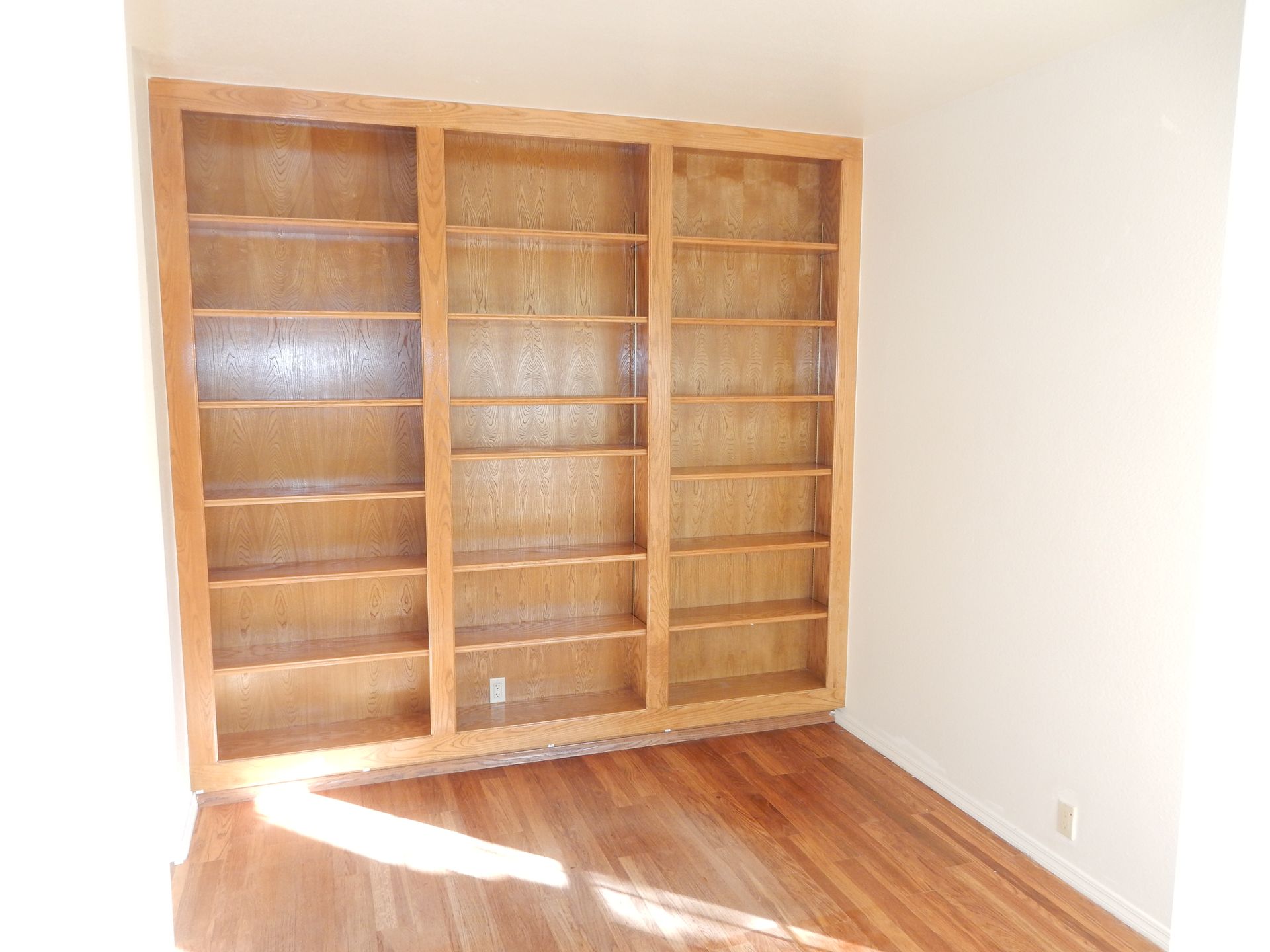 A room with wooden shelves and hardwood floors.