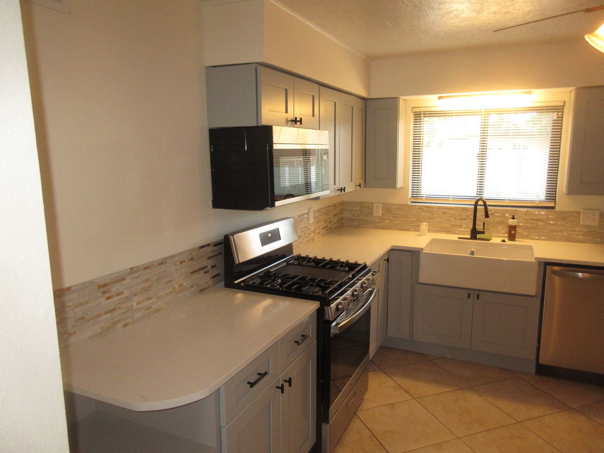 A kitchen with a stove a sink and a window