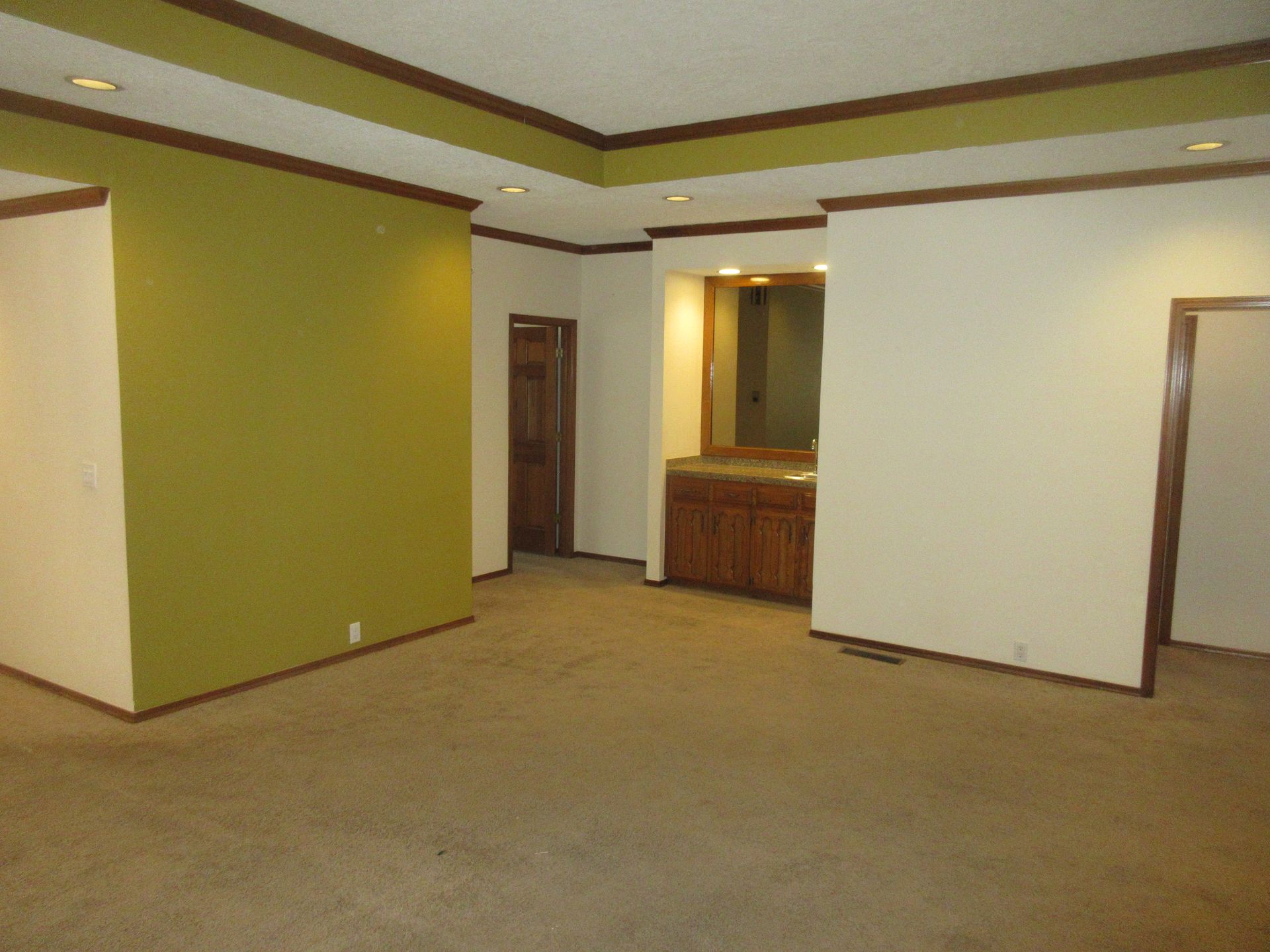 An empty room with a green wall and white walls