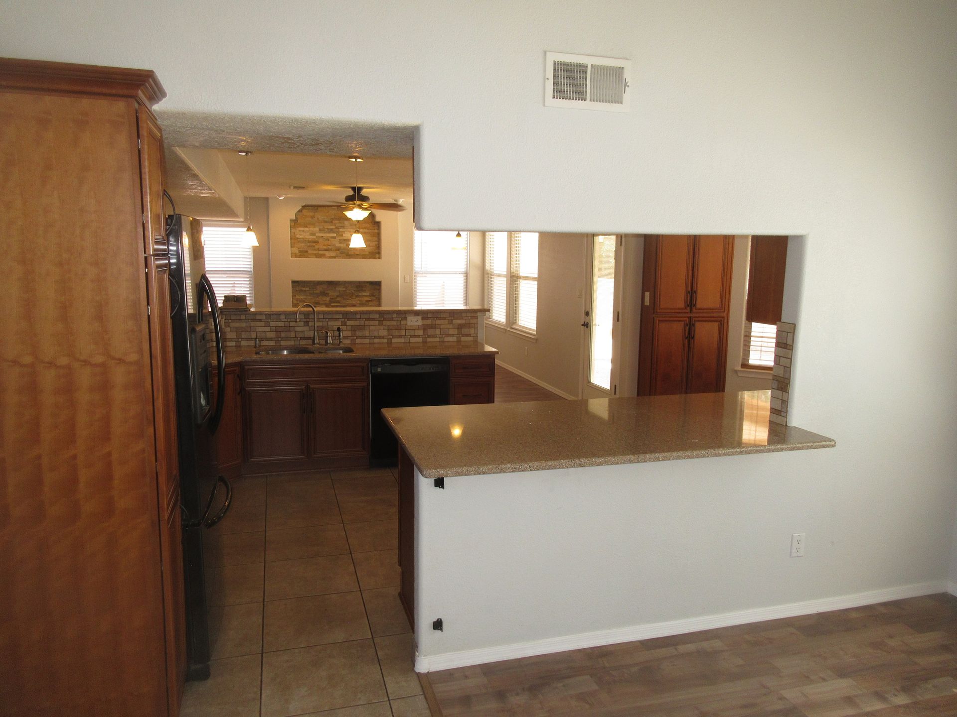 A kitchen with a counter top and a ceiling fan