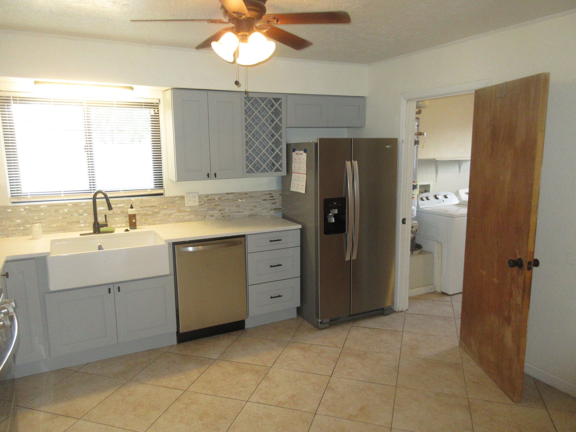 A kitchen with stainless steel appliances and a ceiling fan
